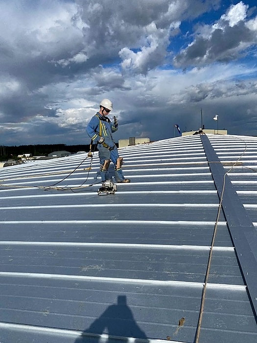 Standing seams being folded shut along the new galvalume tank roof
